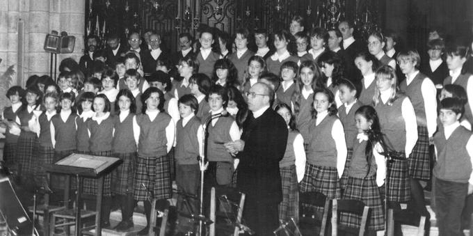 Devant la chorale, Frère André s'adresse à une assemblée